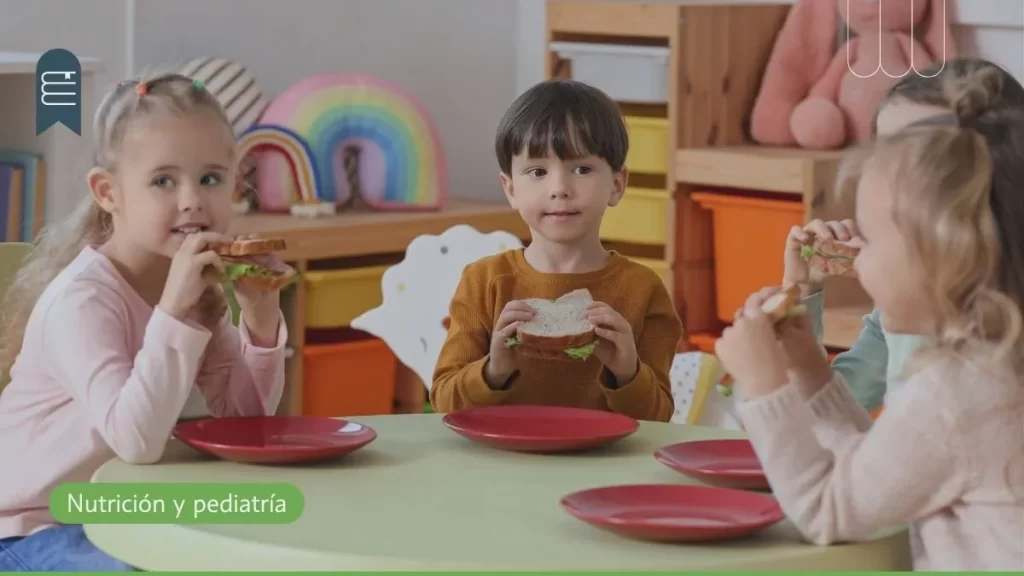 Niños comiendo lonchera escolar saludable en el colegio